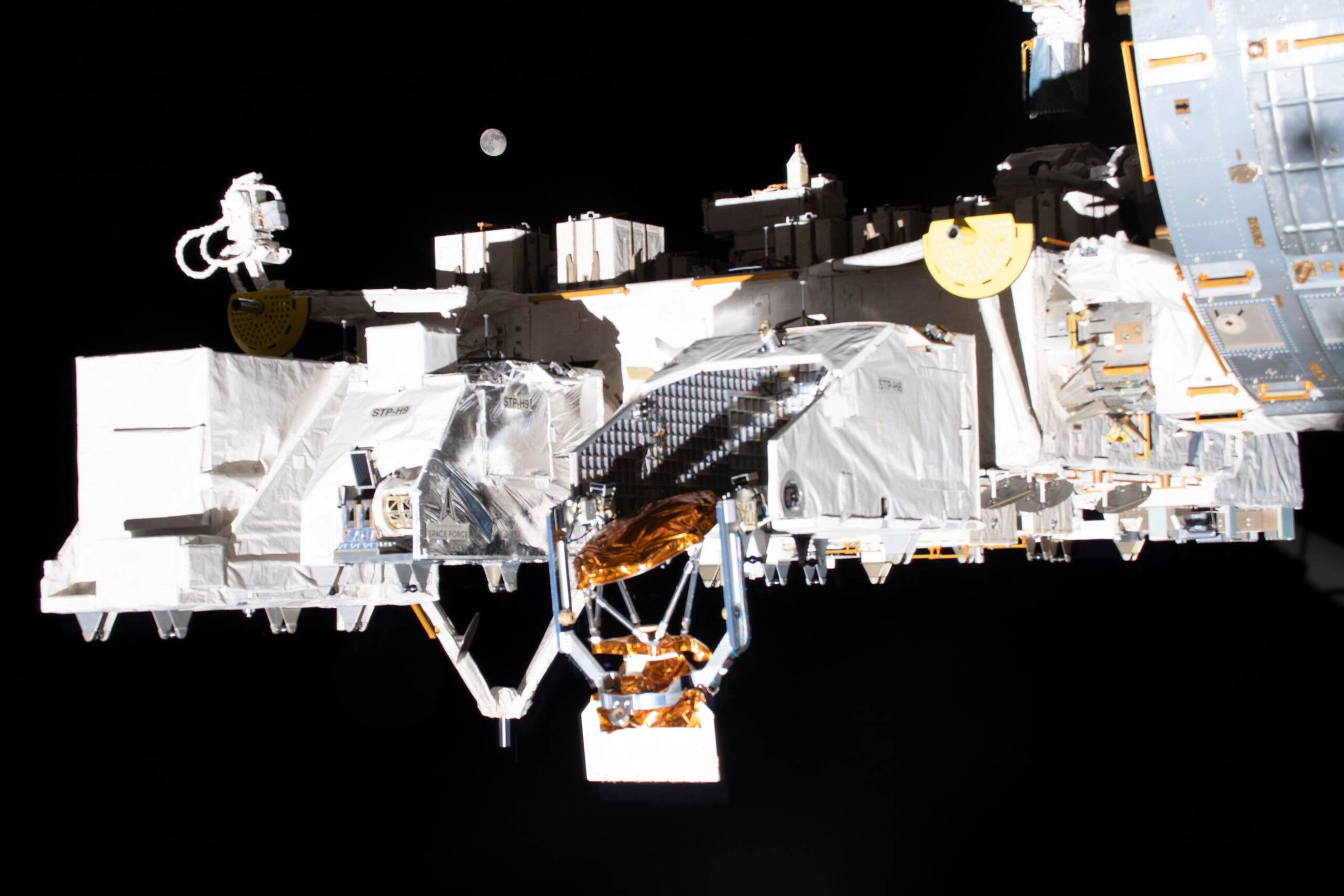 ISSから撮影された船外実験プラットフォーム。その先には月が見える　写真提供：JAXA/NASA