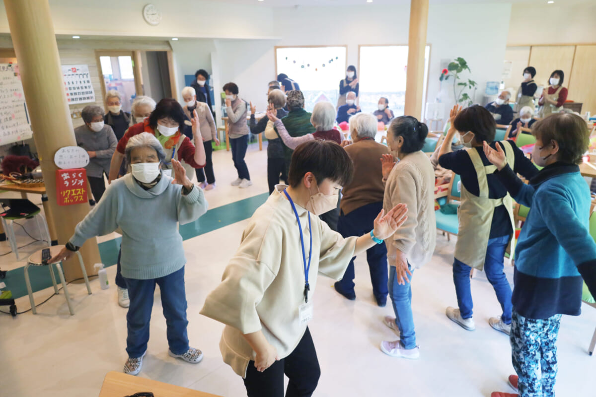 デイサービス中に「一芸発表会」を開催。利用者の皆さんと踊る白神さん(写真中央)