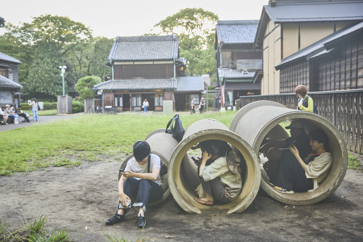 Bチームの作品「下町中通り物語」を鑑賞。右端の土管の手前が大石将弘さん。　下町中通りにて　提供：江戸東京たてもの園　撮影：中島佑輔　