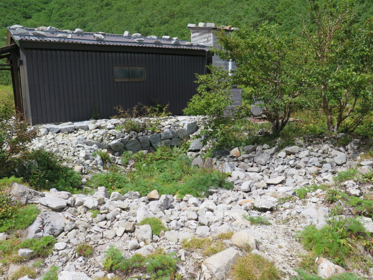 小屋の隣にも低い場所があり、一部は石積み。これはおそらく昔の石室の跡だ