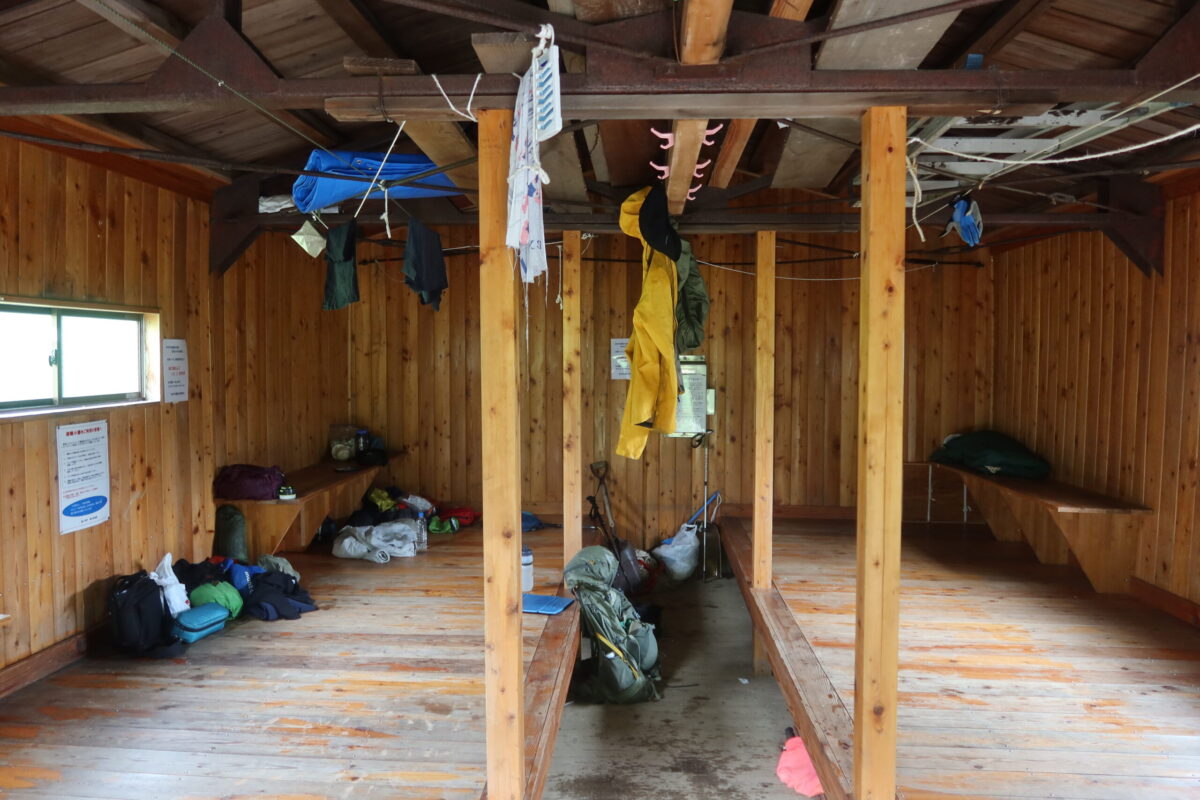 汗で濡れたウェアなどをハンガーにかけて干す登山者もおり、小屋内はだんだん雑然とした雰囲気に