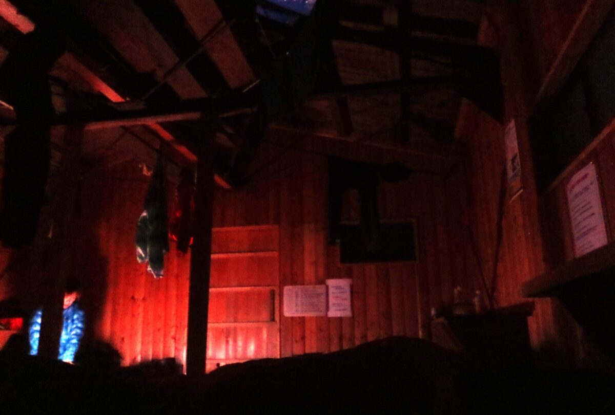 夜の小屋内。赤い光はヘッドランプの明かり(赤い光は寝ている人の目を刺激しにくいため、就寝時間中に使われることが多い)で、おどろおどろしさを演出しているわけではない