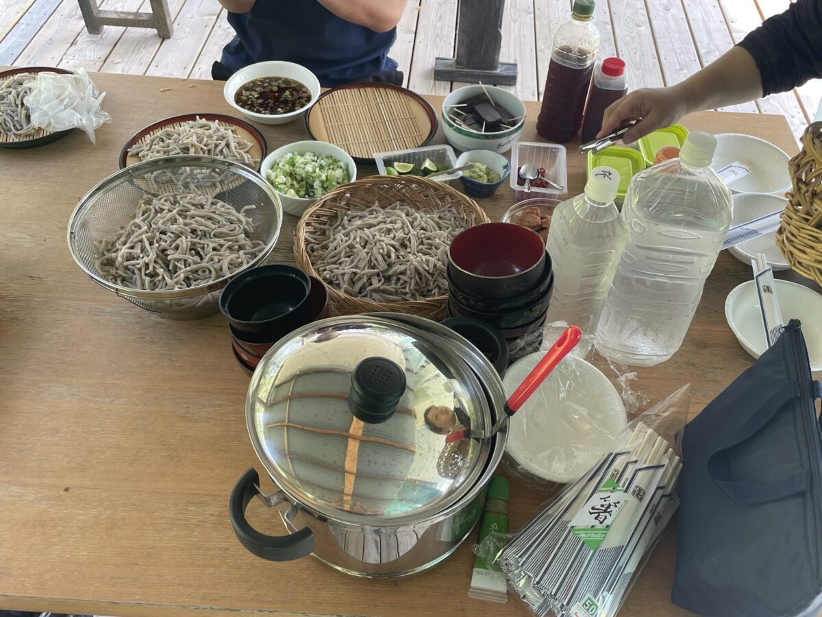 （写真上・下）藍染めした布の下で昼食会　提供：あべさやか