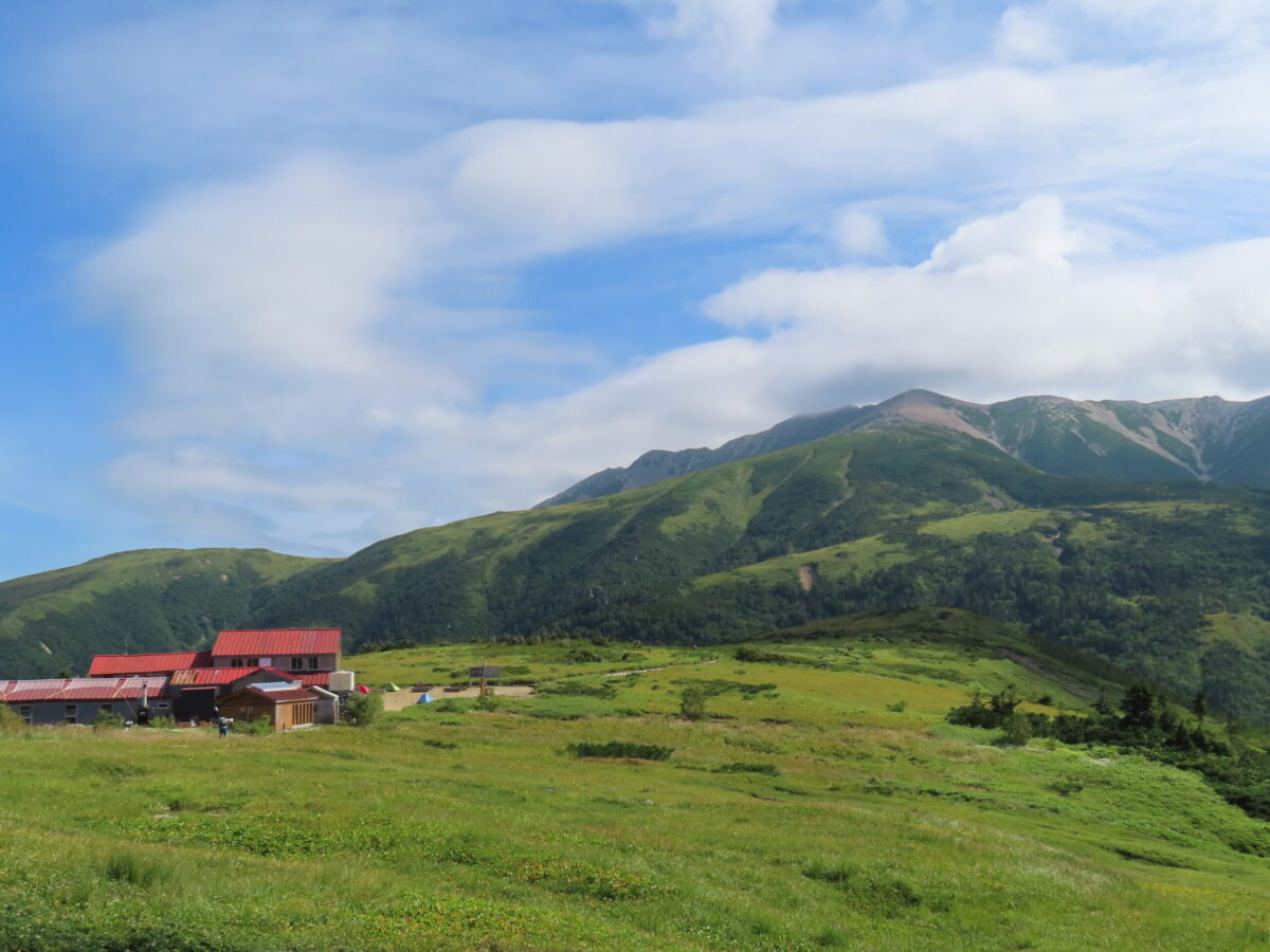 奥に薬師岳がそびえる稜線上の薬師峠小屋。ここから折立への登山道は非常に歩きやすく、登山者も多い