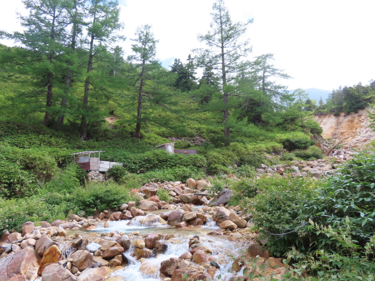 小屋から歩き続け、やっと見えてきた高天原温泉。左のほうに小さな小屋のようなものが2つあるのがわかるだろうか?