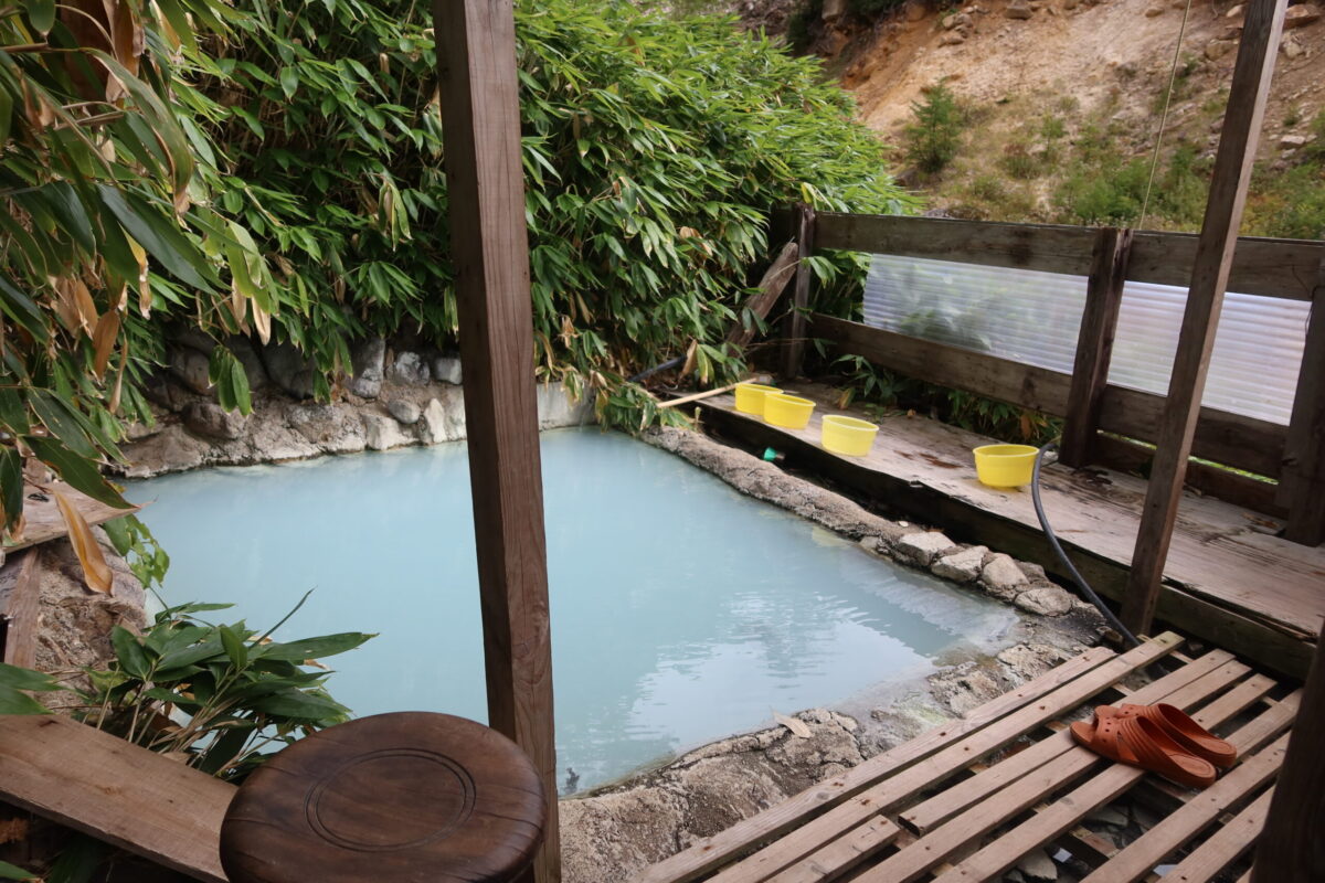 小屋掛けされたなかには、2m四方ほどの露天風呂。石を重ねて固定した湯船のなかに白濁したお湯があふれている