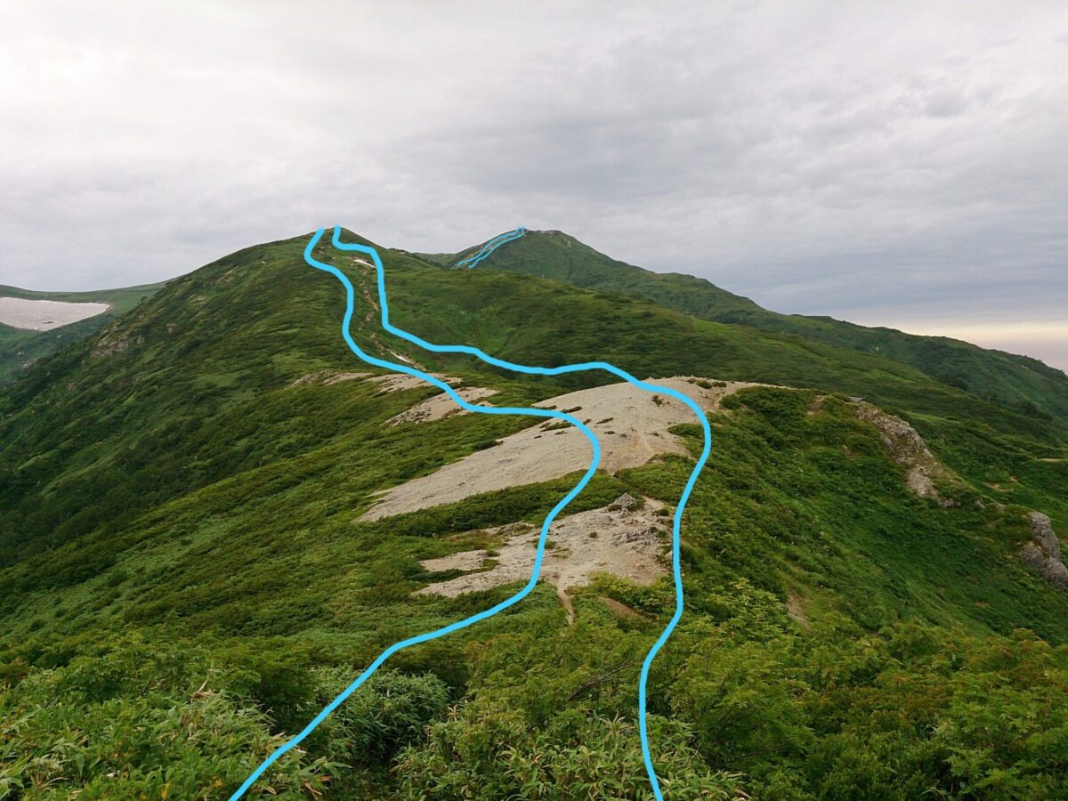 三国岳から飯豊山方向へ向かう稜線。奥に飯豊山が見える。この写真でいうと、青い2本の線の内側が福島県で、右が山形県、左が新潟県となる