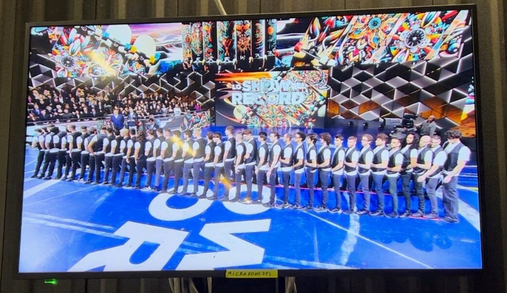 スタジオ内のモニターに映し出された収録の様子。「スケートボードに乗って40人の人間トンネルをくぐる犬」ギネス世界記録挑戦のために40人の男たちが並んだ